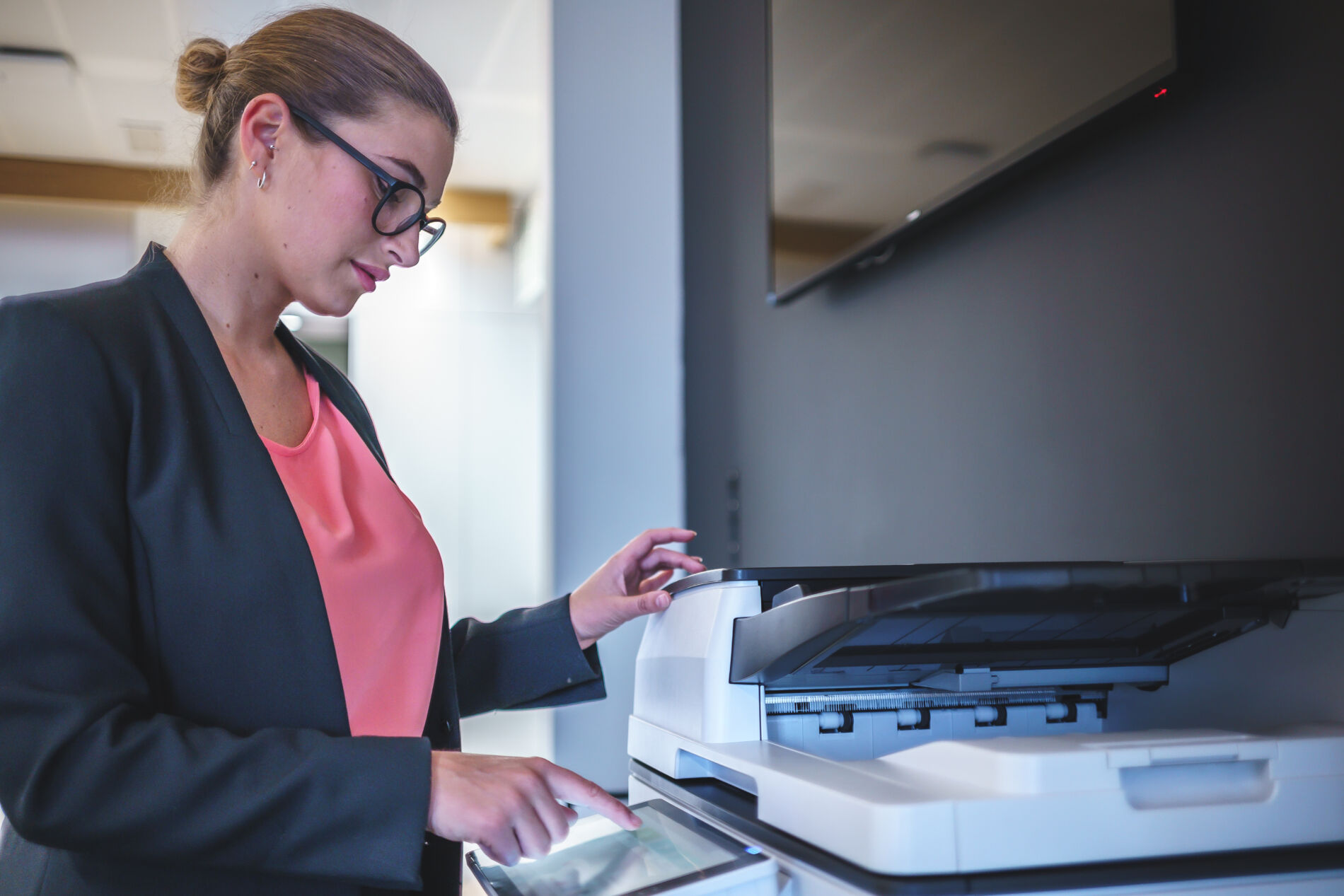 Businesswoman operating printing machine in office